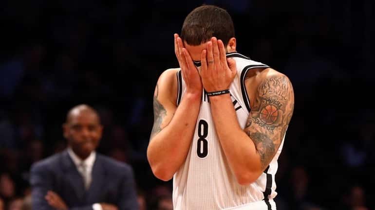 Deron Williams wipes his face during the first half of...