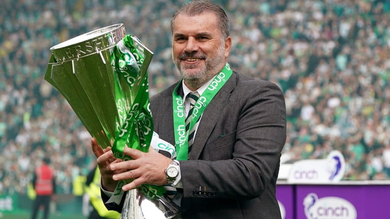 Celtic manager Angelos Postecoglou celebrates with the league trophy after...