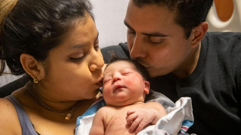 Giselle Delahoz and Jose Francisco Adrian hold their new baby...