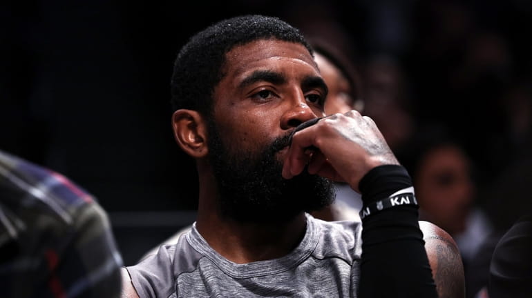 Kyrie Irving #11 of the Brooklyn Nets looks on from...