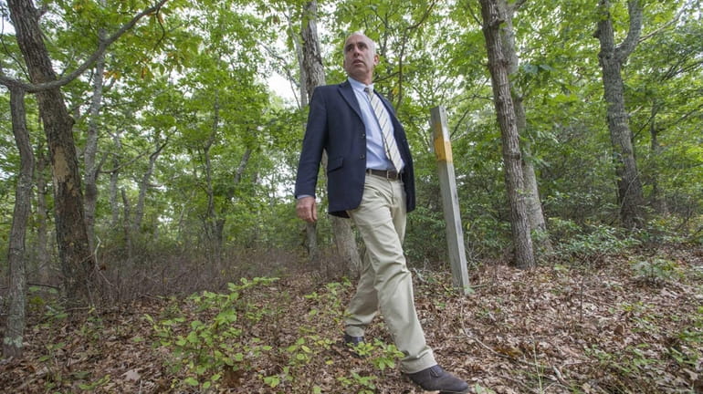 Suffolk County legislator Jay Schneiderman walks by a marker that...