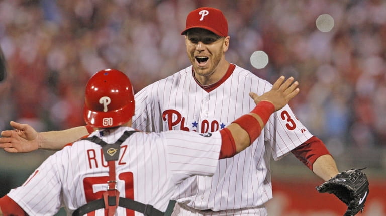 Philadelphia Phillies pitcher Roy Halladay and catcher Carlos Ruiz celebrate...