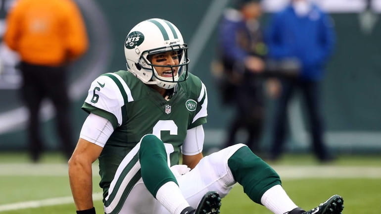Mark Sanchez looks on after he was knocked down in...