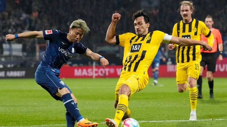 Bochum's Takuma Asamo, left, and Dortmund's Mats Hummels challenge for...