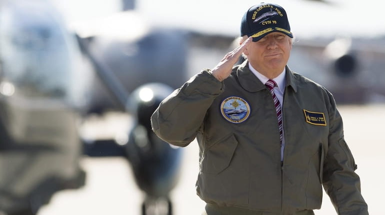 President Donald Trump salutes as he walks to Air Force...