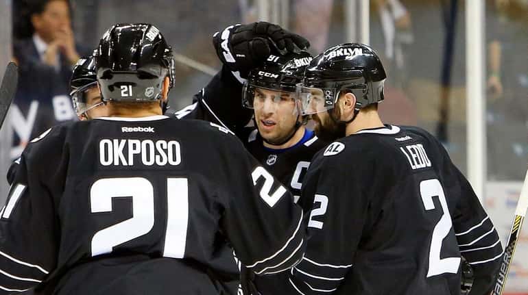 John Tavares, center, celebrates with Islanders teammates after scoring his...