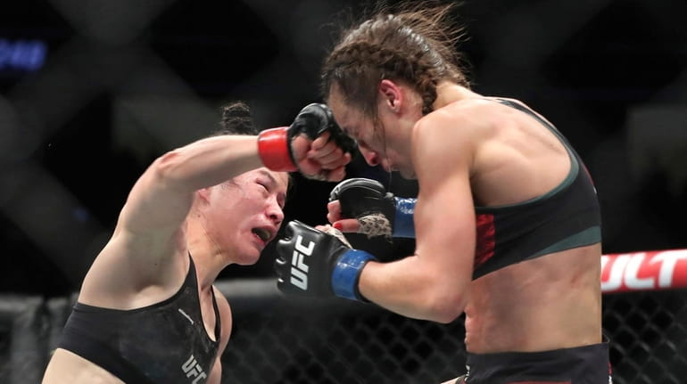 UFC women's strawweight champion Zhang Weili, left, of China punches...