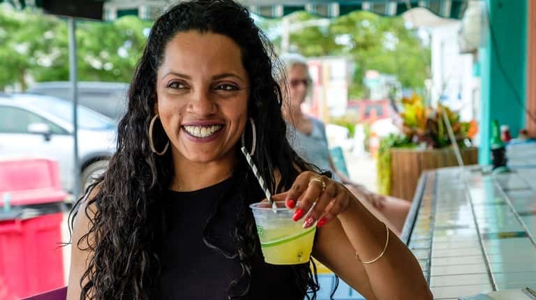 Joseline Rodriguez of Freeport enjoys a drink at Ted's Fishing Station...