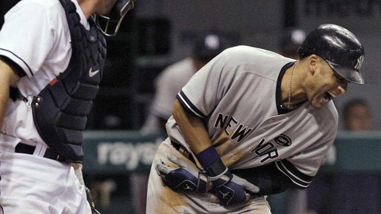 New York Yankees' Derek Jeter, right, screams after being hit...