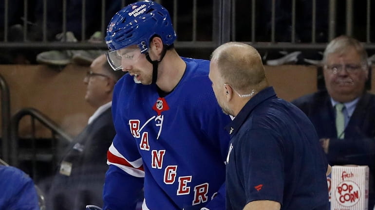 Filip Chytil of the New York Rangers is helped off...