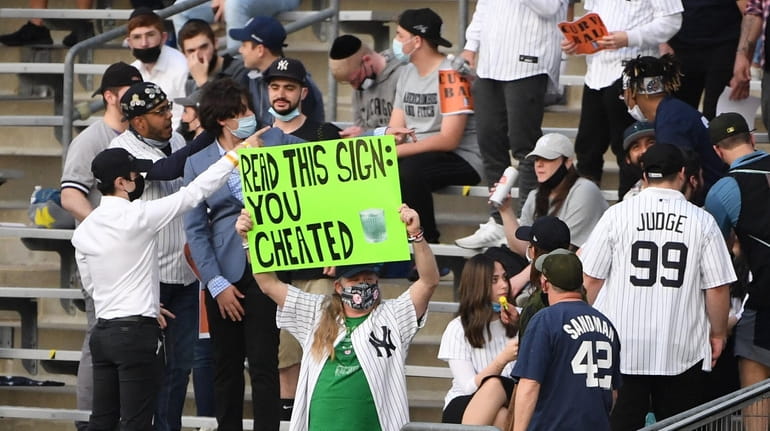 A fan holds a sign before a game between the Yankees and...