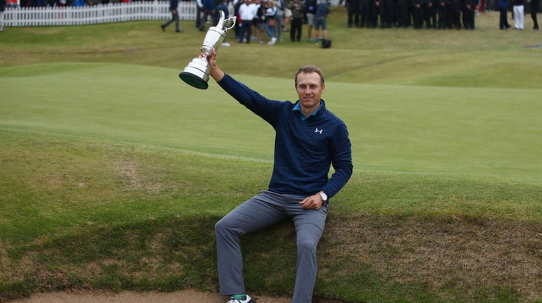 Jordan Spieth of the United States holds the trophy after...