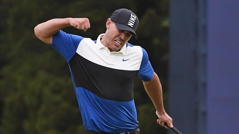 Brooks Koepka reacts after he sinks his putt on the...