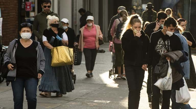 Pedestrians walk along a street in Brooklyn in October.