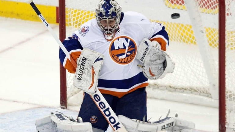 New York Islanders goalie Evgeni Nabokov allows a goal on...
