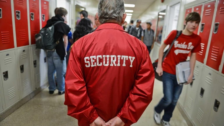 The head of security patrols the halls at Center Moriches High...