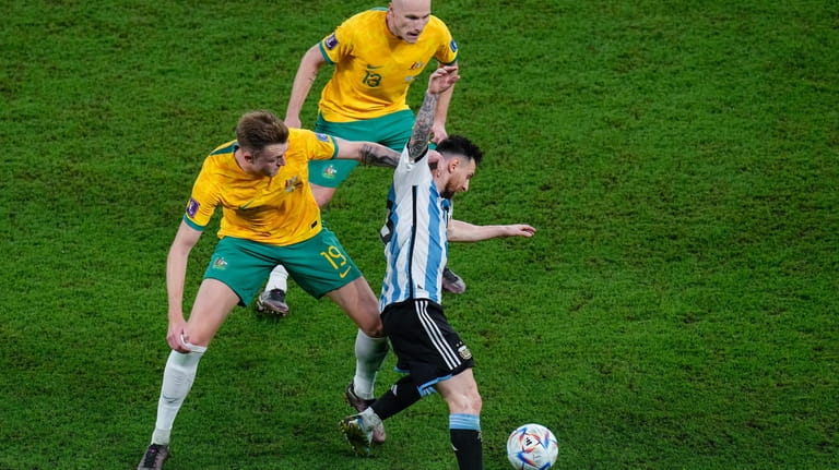 Argentina's Lionel Messi, right, tussles for the ball with Australia's...