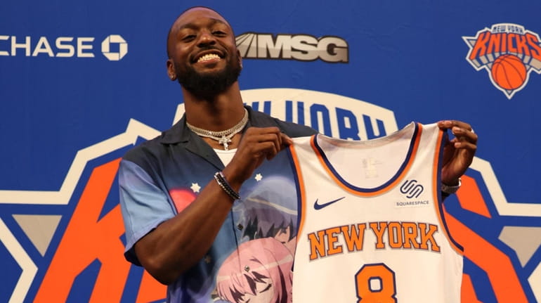 Kemba Walker of the Knicks holds up his jersey after...