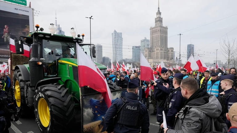 Polish farmers with national flags and angry slogans written on...