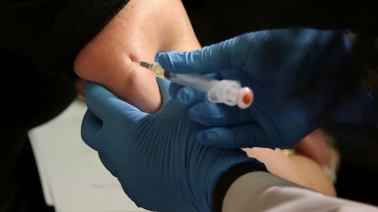 A woman receives a measles, mumps and rubella vaccine at...
