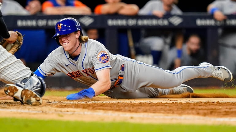 The Mets' Brett Baty is tagged out at home plate...