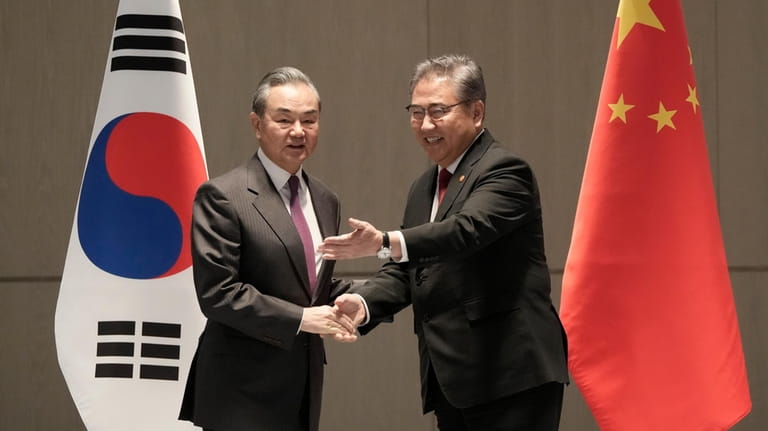 South Korean Foreign Minister Park Jin, right, escorts his Chinese...
