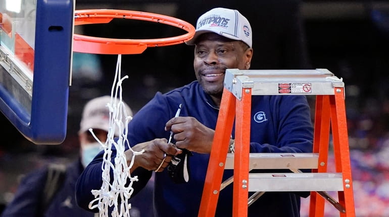 Georgetown head coach Patrick Ewing cuts down the net after...