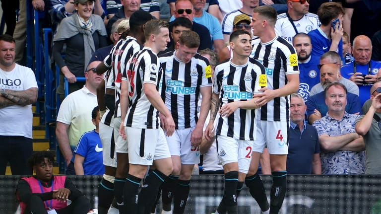Newcastle United's Anthony Gordon, obscured, celebrates with teammates scoring his...