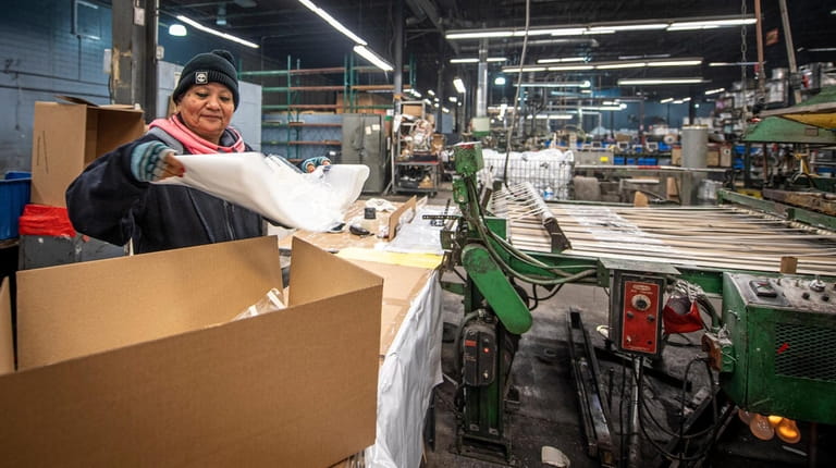 Machine operator Amalia Cruz, 54, of Huntington, packaging printed plastic...