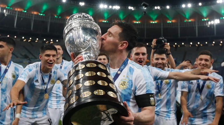 Argentina's Lionel Messi kisses the trophy after beating Brazil 1-0...