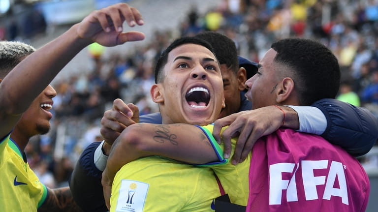 Brazil's Matheus Martins, center, celebrates with teammates after scoring his...