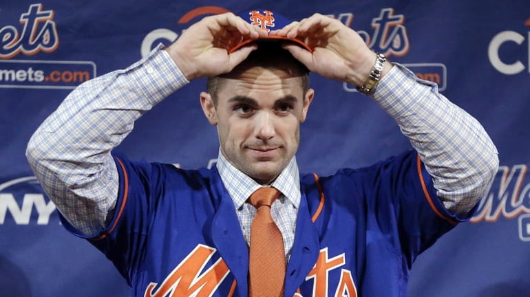 David Wright puts on a Mets cap and jersey during...