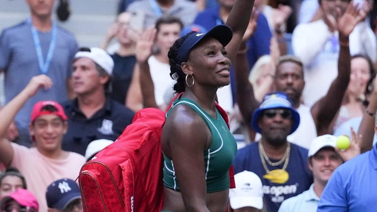 Venus Williams waves to the crowd after losing to Alison Van...
