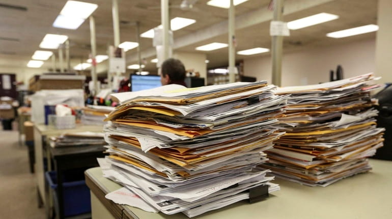 Property tax files are stacked for processing by clerks at...