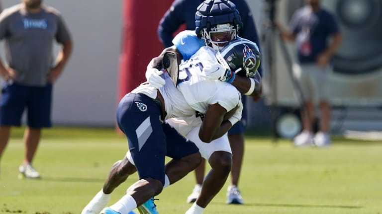 Tennessee Titans linebacker Otis Reese IV wraps up wide receiver...