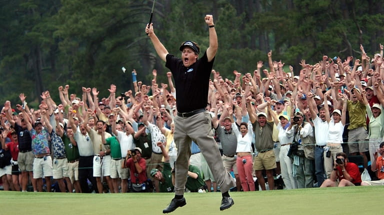 Phil Mickelson celebrates after winning the Masters golf tournament with...