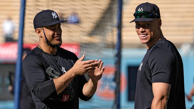 Yankees' Giancarlo Stanton, left, and Aaron Judge talk as they...