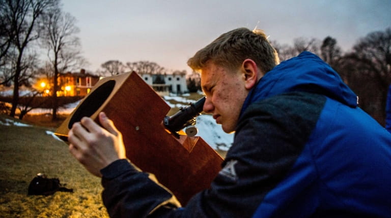 Matthew Kerner looks through a telescope recently at the Custer...