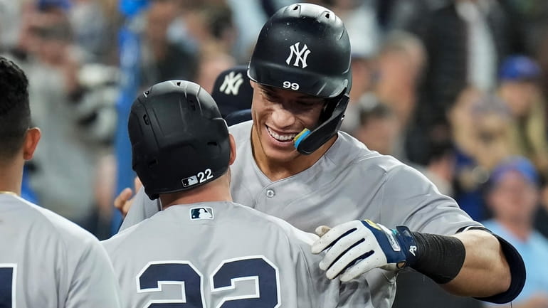 The Yankees' Aaron Judge, right, is congratulated by teammates, including...