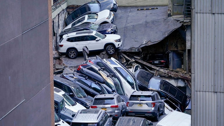 Vehicles piled on top of each other at the scene of...