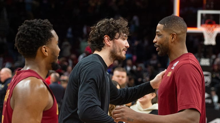 San Antonio Spurs' Cedi Osman, center, is greeted by Cleveland...