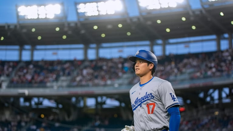 Los Angeles Dodgers designated hitter Shohei Ohtani jogs back to...