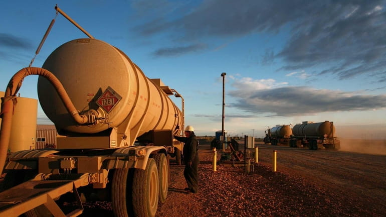 Oil obtained from fracking is transferred into a tanker truck...