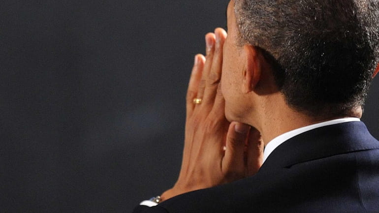 President Barack Obama waits to speak at an interfaith vigil...