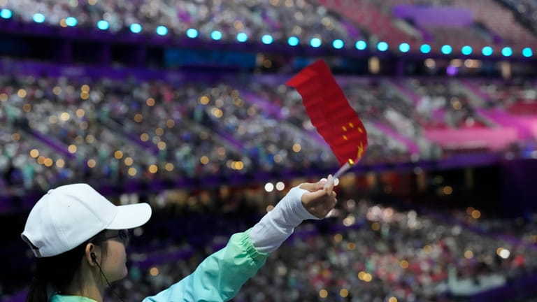 A volunteer waves a flag ahead of the opening ceremony...