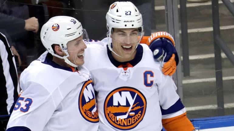 Islanders left wing Anders Lee, right, celebrates with center Casey...