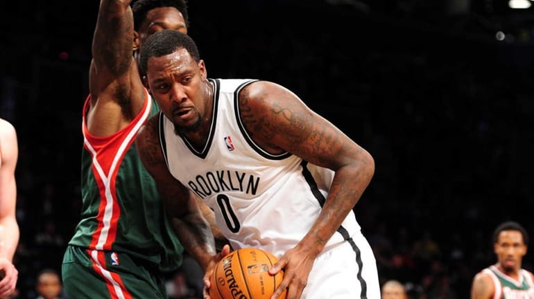 Andray Blatche of the Brooklyn Nets is guarded by Larry...
