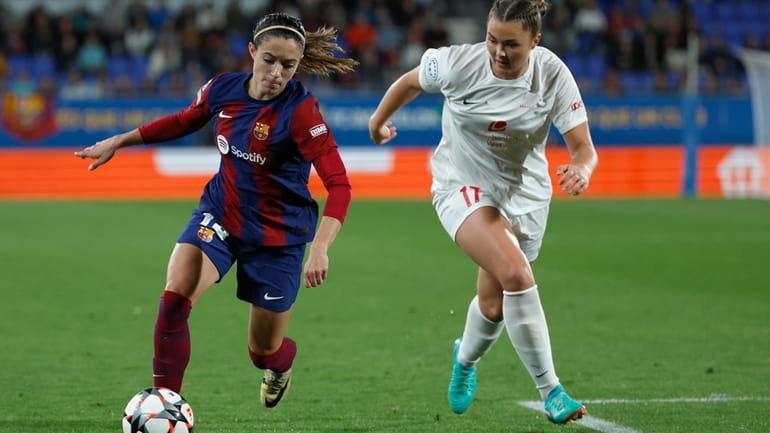 Barcelona's Aitana Bonmati, left, challenges for the ball with Brann's...