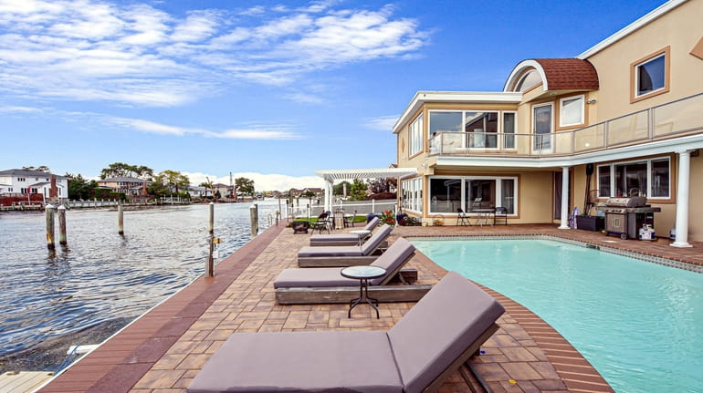 The 3,663-square-foot stucco home has a pool and patio overlooking a canal.