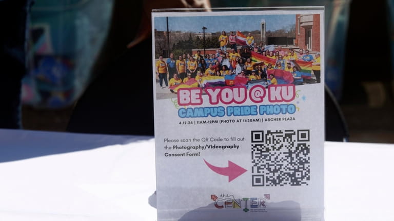 A sign promoting a campus LGBTQ+ pride photo sits on...